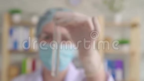 一位年轻女子在化学实验室用长玻璃吸管将红色液体滴入试管视频的预览图