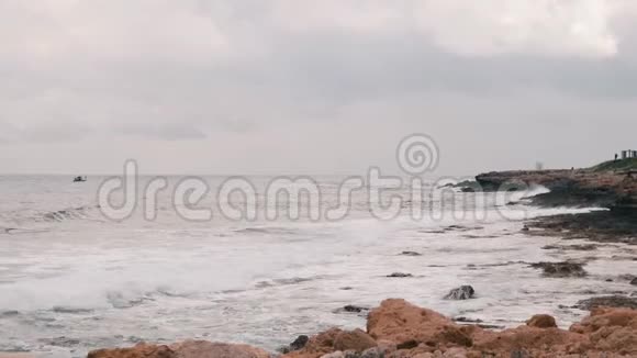 美丽的地中海大岩石海滩巨大的海浪撞击岩石海岸海浪创造泡沫和飞溅SS视频的预览图