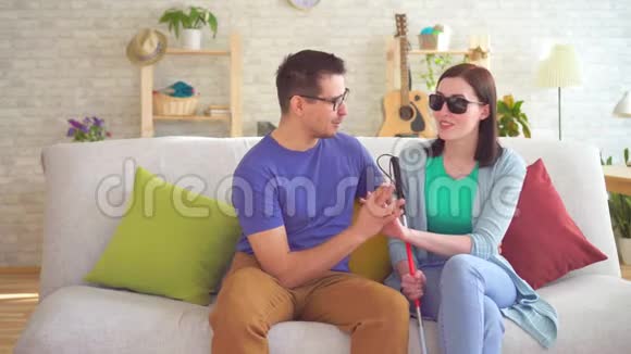 一个年轻男子和一个坐在沙发上的盲人残疾妇女调情视频的预览图