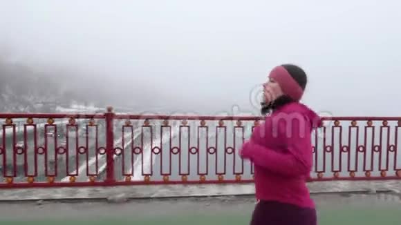 年轻胖乎乎的白种人女孩在桥上奔跑侧射紫色服装视频的预览图