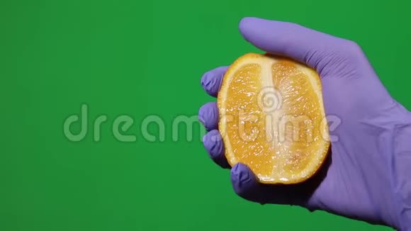 捏着鲜橙孤立的绿色背景视频的预览图