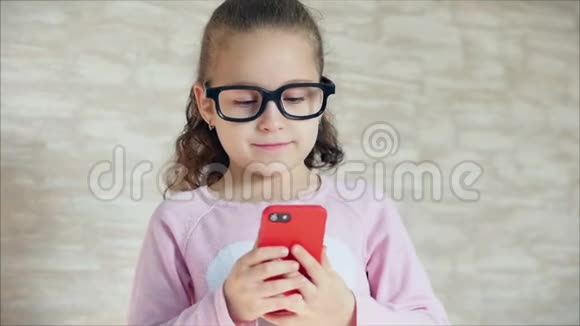 小女孩用手机或平板电脑娱乐小女孩把空闲时间花在玩手机游戏上玩得很累视频的预览图