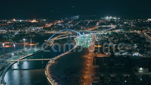迪拜水上运河从市中心的摩天大楼屋顶俯瞰人行天桥夜景视频的预览图