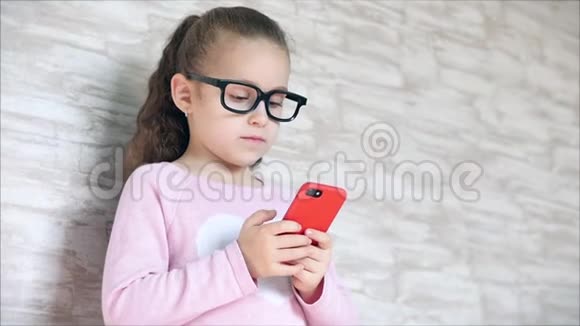 可爱的婴儿用手机或平板电脑娱乐小女孩把空闲时间花在玩手机游戏上玩得很累视频的预览图