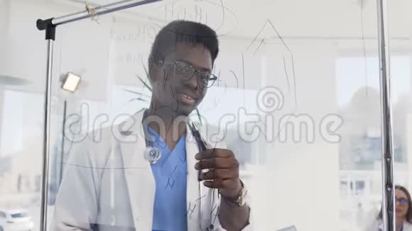 年轻的非洲医生在医院的会议室里写了一些医学配方非裔美国医生视频的预览图