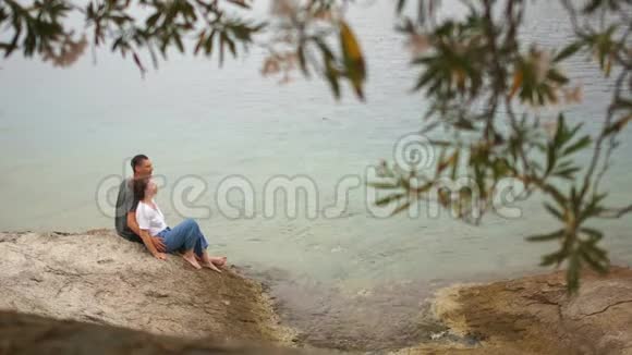 男人和女人接吻一对情人夫妻情人节在岩石海岸的年轻夫妇视频的预览图