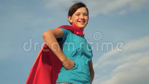 少女女超级英雄穿着红色斗篷站在田野上斗篷随风飘扬慢动作特写镜头女孩的梦想视频的预览图