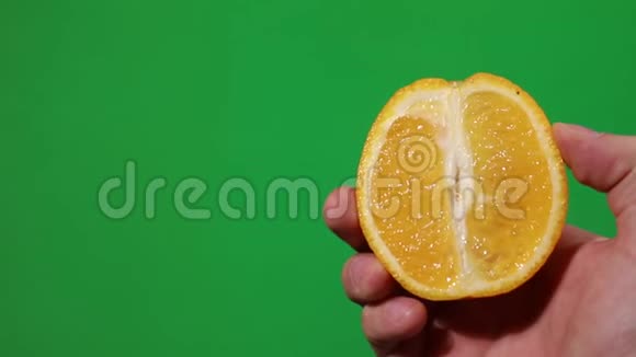 手挤压橙色色度背景挤压果汁视频的预览图