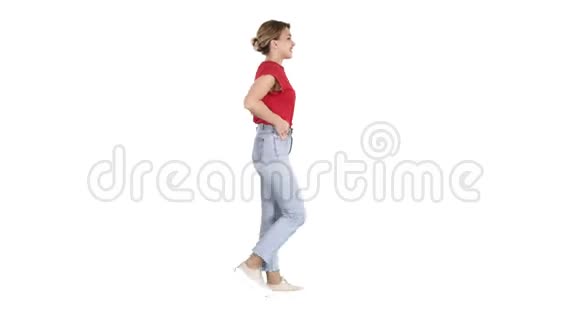 合身的女孩双手抱在蓝色牛仔裤口袋里走在白色的背景上视频的预览图