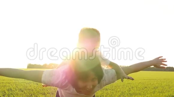 妈妈和孩子用手展示飞机妈妈和她的小儿子在户外玩得很开心妈妈把孩子抱起来视频的预览图