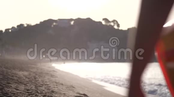 苗条的金发女人穿着淡紫色比基尼在海滩上散步视频的预览图