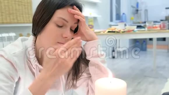 悲伤的女人触摸蜡烛的火和思考视频的预览图