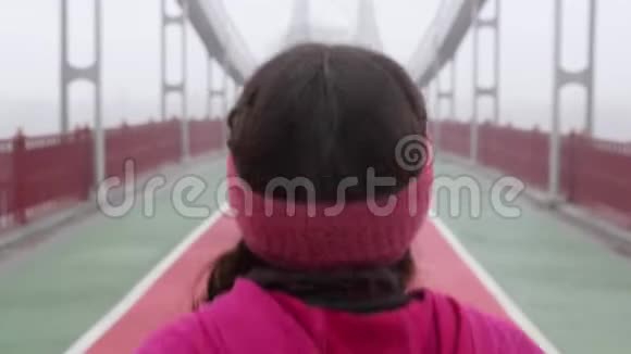 年轻胖乎乎的白种人女孩在桥上奔跑后面跟着射击慢动作紫色服装视频的预览图