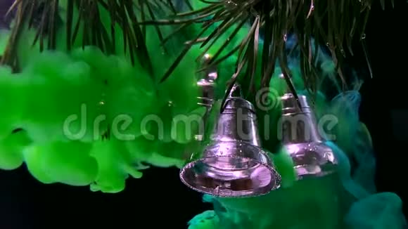 闪亮的银色圣诞铃铛挂在冷杉树枝上绿色时尚的现代背景视频的预览图