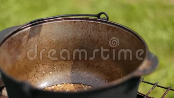 男人把红色调味料放在一个大的铸铁锅里里面放着炒洋葱视频的预览图