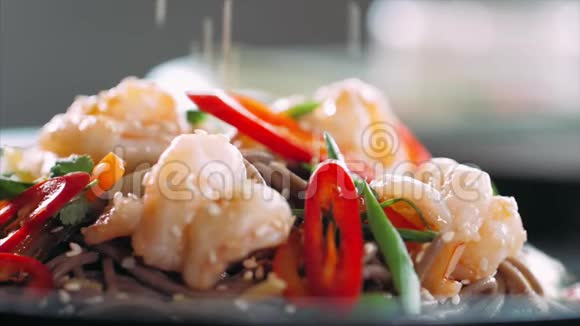芝麻落在传统的亚洲荞麦上用虾炒面视频的预览图