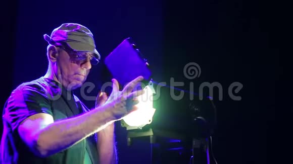 一位男性照明者在聚光灯下打开窗帘视频的预览图