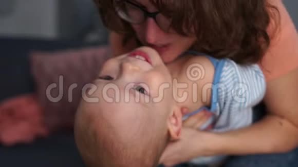 母亲抱着儿子在卧室里做倒立妈妈和儿子在家玩得开心笑着和傻瓜在一起亲密视频的预览图