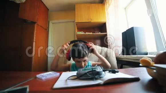 一个小男孩戴上耳机打开盒式录音机俄罗斯旧内饰视频的预览图