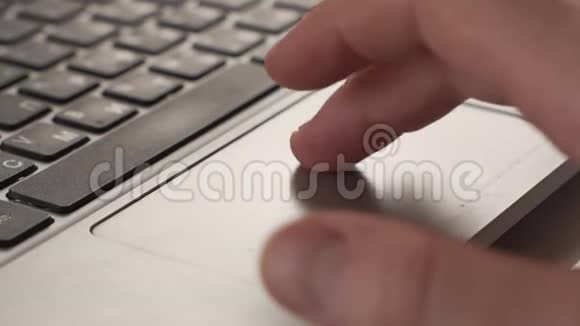 使用笔记本电脑跟踪垫滚动网站的人的特写镜头视频的预览图