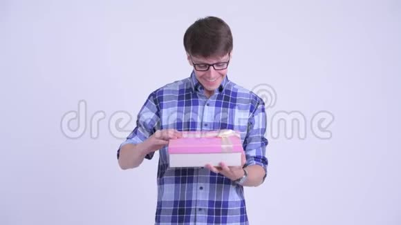 快乐的年轻时髦男人打开礼物盒看上去很惊讶视频的预览图