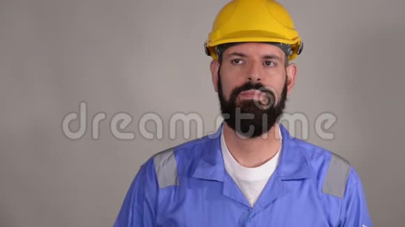 戴着头盔的胡子男建筑工人准备用手指写东西视频的预览图