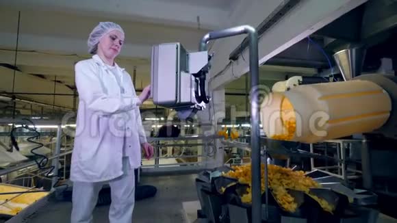 女人在食品生产工厂控制一台工作机器动作缓慢视频的预览图