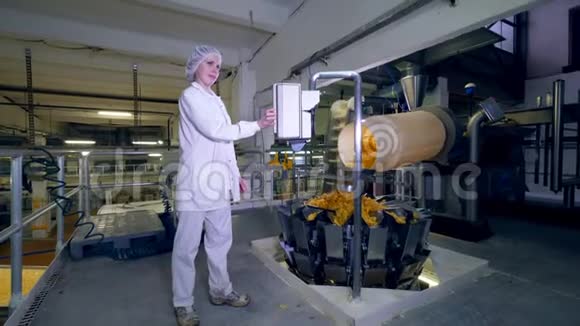 一个人在工厂机器上工作而薯片在传送带上移动视频的预览图