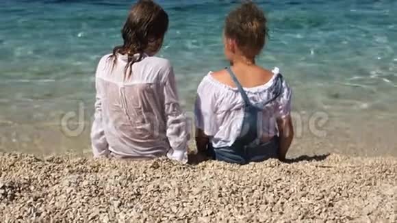 穿着湿衣服的男孩和女孩在克罗地亚游泳暑假和度假后坐在海滨视频的预览图