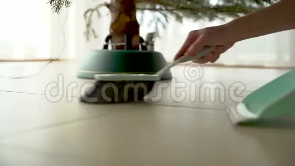 用扫帚和铲子清理圣诞树下的针头视频的预览图