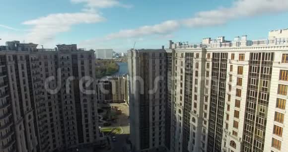 一座现代化的大型住宅建筑的鸟瞰图及其背后的阳光城市景观视频的预览图