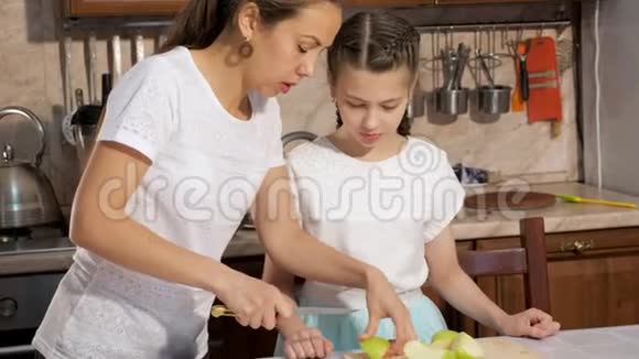 妈妈教她女儿如何把苹果切成小块视频的预览图