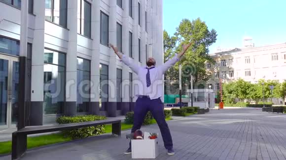 被解雇了穿着正式服装的英俊的商人在经过商务中心时高兴跳舞高兴视频的预览图