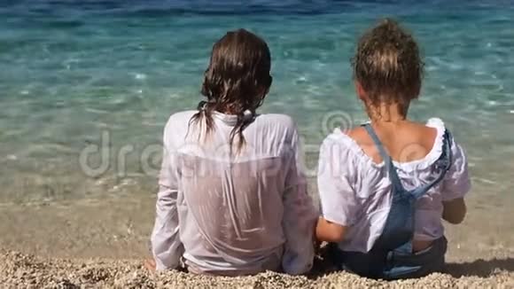坐在海边的快乐学童转过身来微笑暑假兄弟姐妹视频的预览图