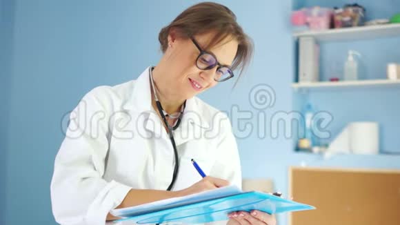 可爱的女医生穿着一件白色的医用外套带着一个听筒看着镜框用白色的微笑视频的预览图