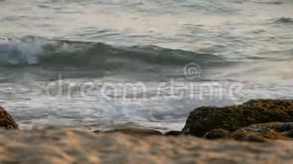4K海浪泡沫泡沫的海水在海滩上与岩石热带夏季海滩度假背景镜头选择性聚焦视频的预览图