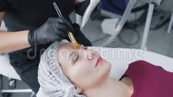 贴身美容师将黑碳面膜敷于女性面部动作缓慢视频的预览图