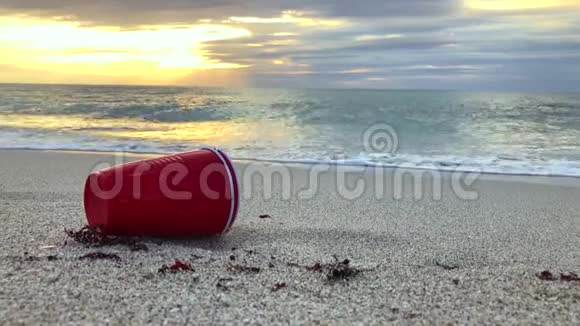 海滩上的红色塑料杯视频的预览图