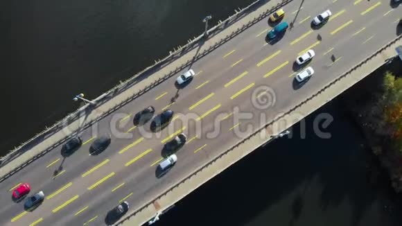 俯视汽车骑在黑暗的河流上的汽车桥上视频的预览图