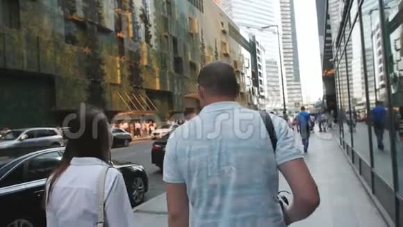 后景的情侣牵手同时看市区的城市天际线几个游客在现代视频的预览图