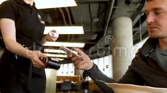 咖啡馆里的男人通过信用卡付款视频的预览图