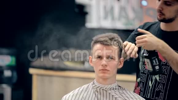 一名男性专业美发师在男士沙龙工作视频的预览图