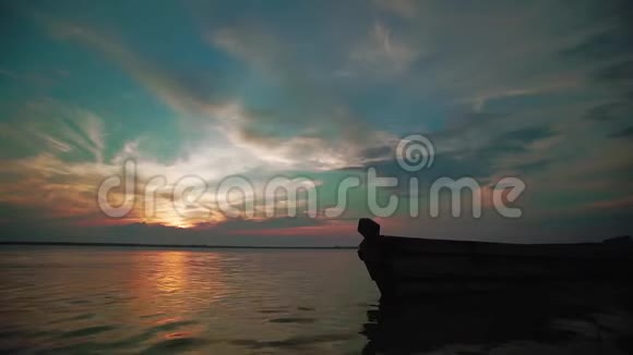 慢动作女人和男人握着手在日落时快乐地沿着湖边奔跑小孩子的剪影视频的预览图