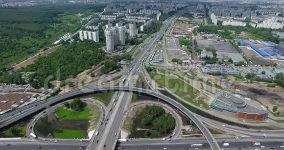 从空中俯瞰绿色城市景观中央一个巨大而繁忙的道路交叉口视频的预览图