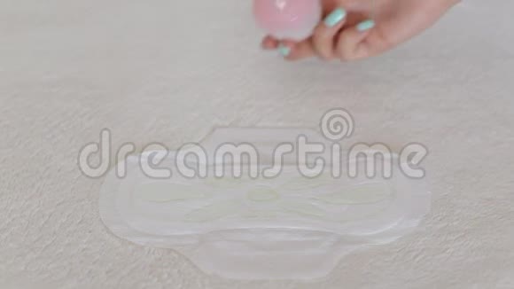一个女孩在月经卫生垫上倒水漏电保护概念特写视频的预览图