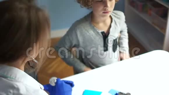 漂亮的医生检查一个年轻的男孩病人听音筒国际医生日儿科视频的预览图