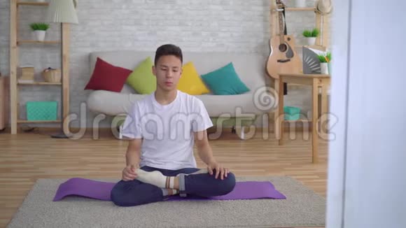 坐在垫子上做瑜伽的韩国年轻人视频的预览图