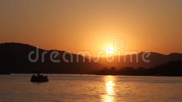 美丽的日落在海上船的轮廓和山丘视频的预览图