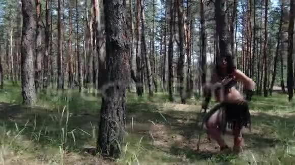 古代穿着旧衣服的野蛮女人正拿着剑站在森林里视频的预览图