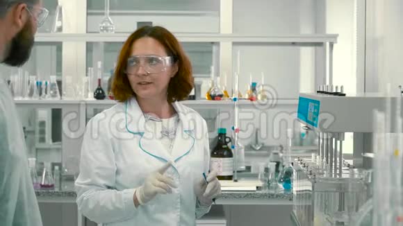 两个化学家在实验室里谈话视频的预览图